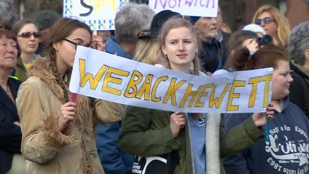 Protestors carry We Back Hewett sign