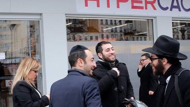 Customers chat outside the Paris kosher supermarket