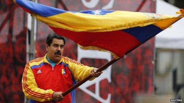 President Nicolas Maduro waves a national flag outside Miraflores Palace in Caracas on 15 March, 2015.