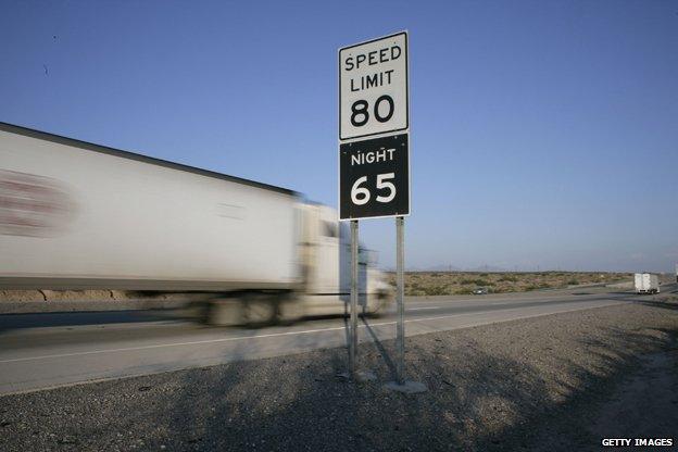 Truck speeds past speed limit sign in US