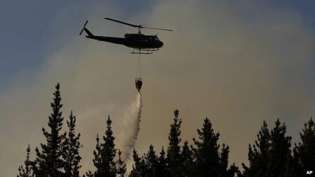 A helicopter dumps water on a forest fire in Valparaiso on 14 March, 2015