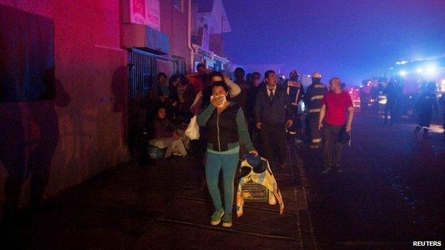 Locals evacuate their homes during a forest fire in the hills of the port city of Valparaiso on 14 March, 2015.