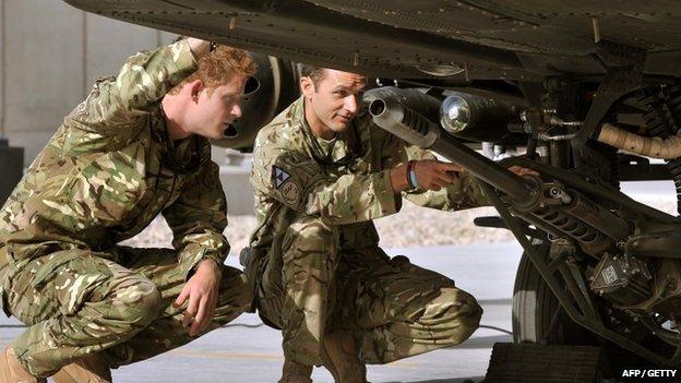 An Apache helicopter is examined by Prince Harry at Camp Bastion in 2012