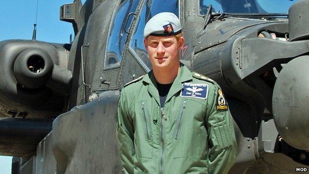 Prince Harry poses in front of an Apache attack aircraft after qualifying as aircraft commander