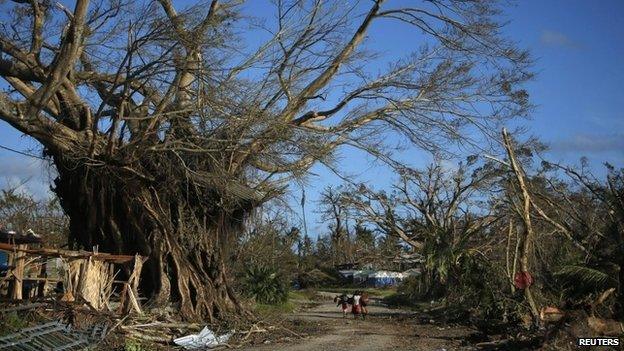 People walk through a street in Lenakel town after Cyclone Pam in Tanna, about 200 km from Port Vila, capital city of the Pacific island nation of Vanuatu March 17, 2015