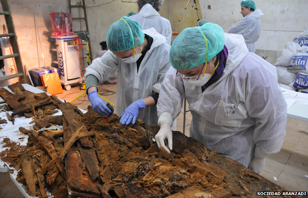 Experts examine the remains of coffins at a table inside the crypt of Madrid's Trinitarian convent in this handout picture released by Madrid's City Hall January 26, 2015