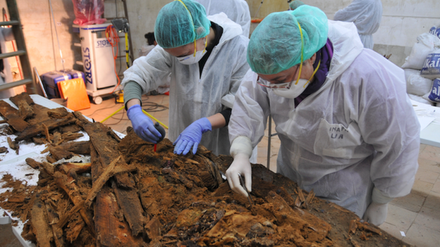 Experts examine the remains of coffins at a table inside the crypt of Madrid's Trinitarian convent in this handout picture released by Madrid's City Hall January 26, 2015