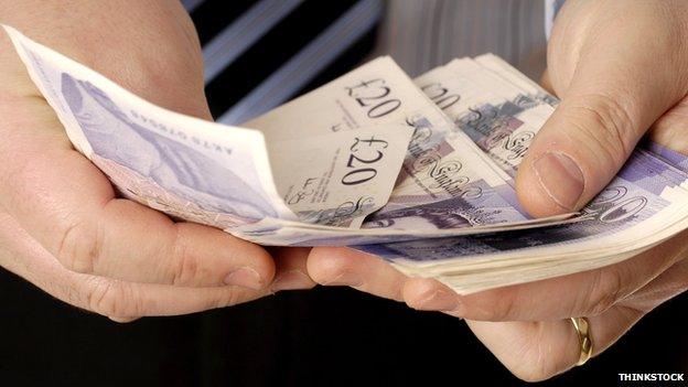 Man's hand with £20 notes