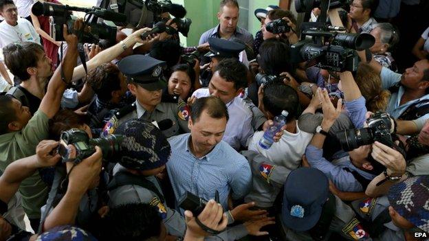 Tun Thurein (centre) is escorted by policemen along with Htut Ko Ko Lwin, and Philip Blackwood after being sentenced two and a half years in prison by a court, (17 March 2015)