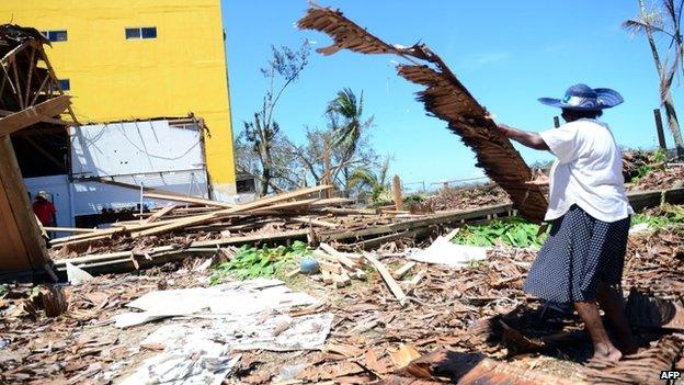 A resident cleans up cyclone damage in Vanuatu's capital Port Vila (17 March 2015)