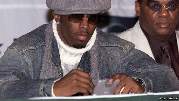 P Diddy looks at his pager, 2002