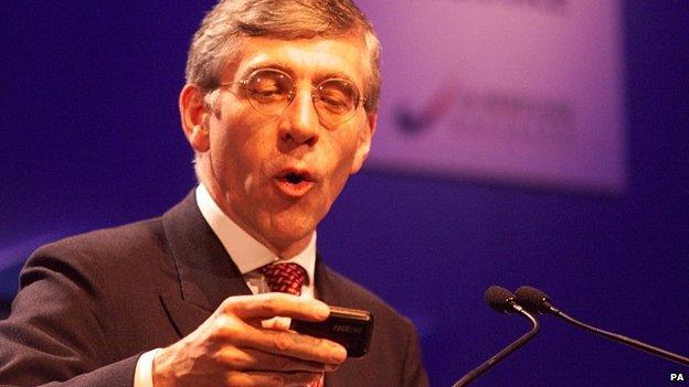 Jack Straw looks at his pager during a speech, 1998