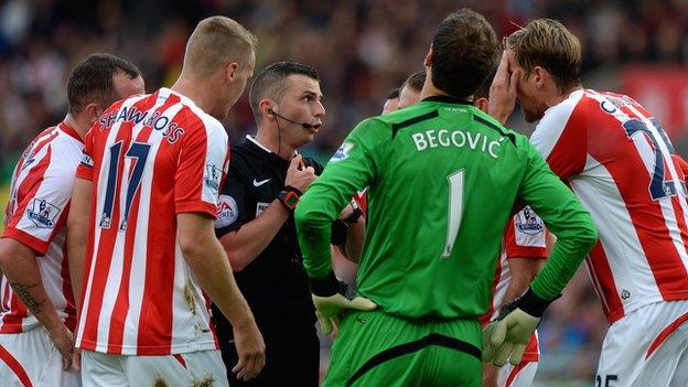 Stoke players surround the referee