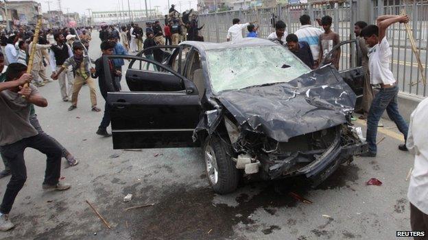 Protesters from the Christian community attack a car during clashes with riot police