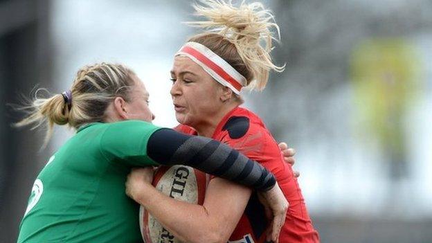 Adi Taviner of Wales is tackled by Niamh Briggs in Swansea