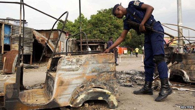 A policeman inspects damage outside a police station that was attacked during violent protests in Kinshasa, Democratic Republic of Congo on 23 January 2015