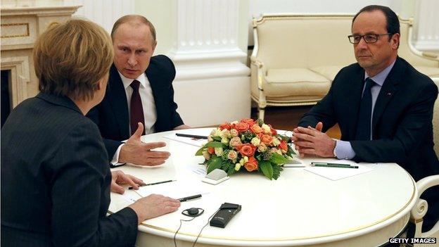 Vladimir Putin and Angela Merkel talking, Francois Hollande looking on, at the Kremlin in February 2015