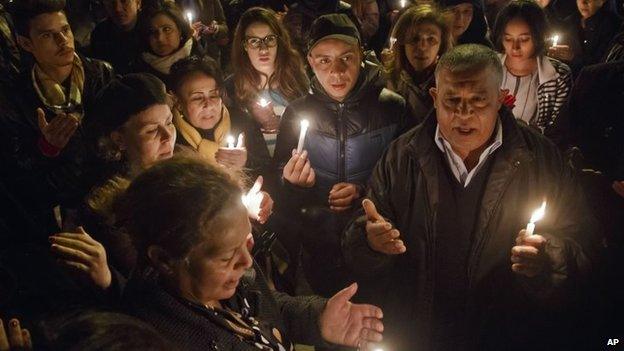 Tunisians holding candles pray at the entrance gate of the National Bardo Museum, Tunis, 18 March 2015