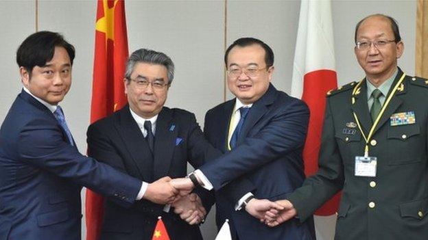 China's Assistant Minister of Foreign Affairs Liu Jianchao (2nd R), Japan's Foreign Deputy Minister Shinsuke Sugiyama (2nd L), and other government officials from both sides shake hands prior to the 13th round of Japan-China Security Dialogue at the Foreign Ministry in Tokyo on March 19, 2015.