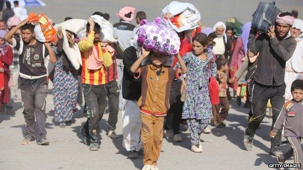 Displaced Iraqi families from the Yazidi community cross the Iraqi-Syrian border at the Fishkhabur crossing, in northern Iraq, on August 13, 2014.