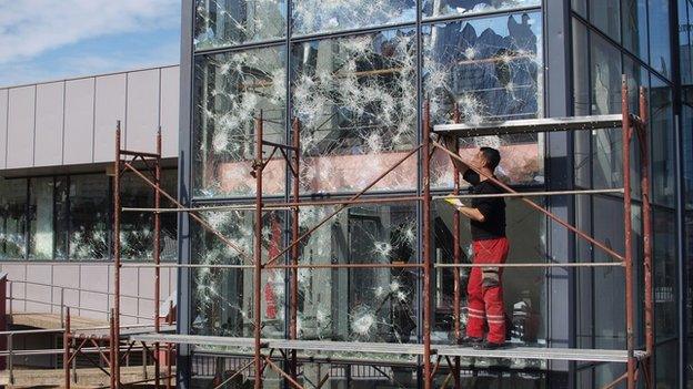 Worker repairs broken windows in Kosovo's capital Pristina, March 2015