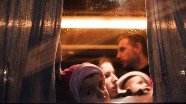 A Kosovo Albanian child and his family sit on a bus heading to Serbia, in Pristina in February 2015, hoping to reach the European Union and seek asylum