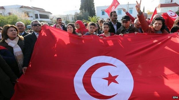 Tunisians wave their national flag as they protest outside the National Bardo Museum in Tunis, Tunisia on 19 March 2015