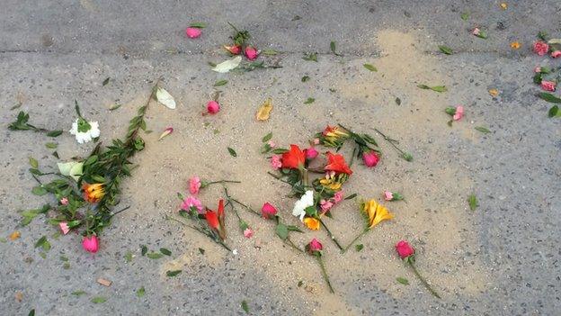 Flowers on ground as memorial to victims