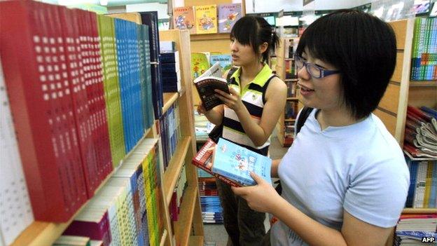 Chinese university students browse through various textbooks during their summer holidays at a book store in Shanghai on 16 August 2014