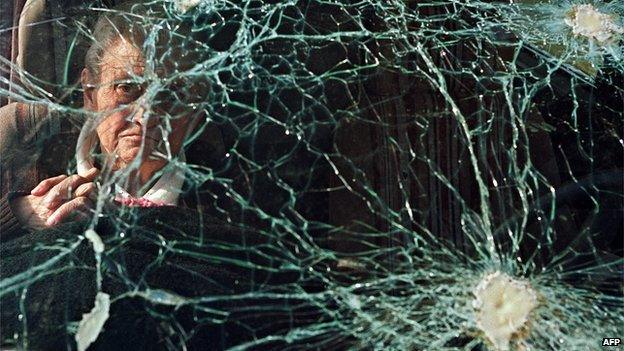 An elderly Bosnian woman waits in a car with bullet marks on the windshield before leaving Sarajevo 10 November 1992