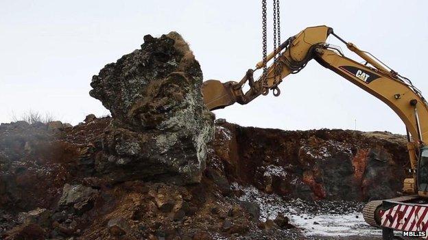 A crane is used to move a rock in Iceland thought to be an elf church to make way for a new road on 18 March.