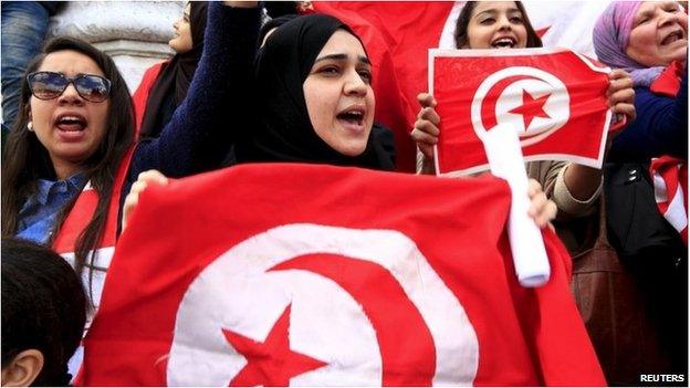 Tunisian protesters shout slogans as they wave banners and their national flag during a demonstration on independence day in Tunis - 20 March 2015