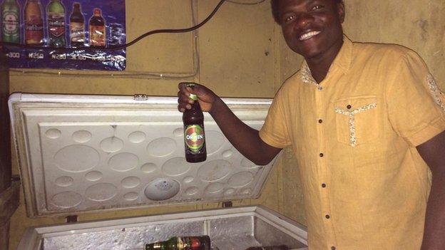 Bar tender Paul Bini in Kano holding a beer