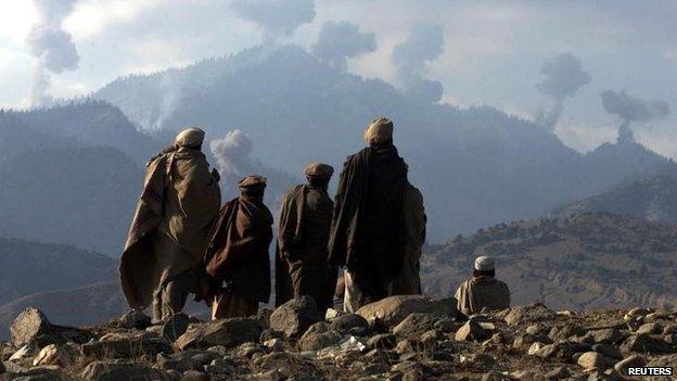 Anti-Taliban Afghan fighters watch several explosions from U.S. bombings in the Tora Bora mountains in Afghanistan, in this 16 December 2001