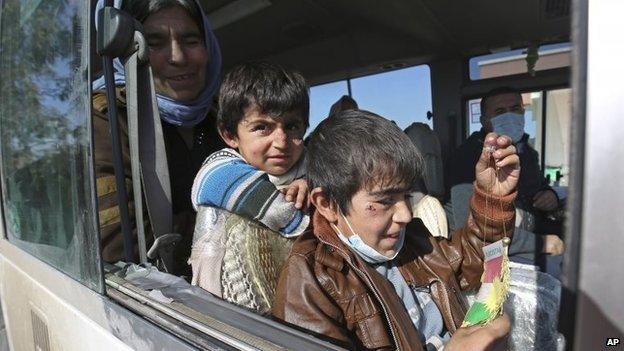 Two Yazidi boys, suffering from several infections from mosquito bites while held by Islamic State, wait with their mother inside a bus before being driven to the Kurdish city of Dohuk, in Alton Kupri, outside Kirkuk, Iraq, 18 January 2015
