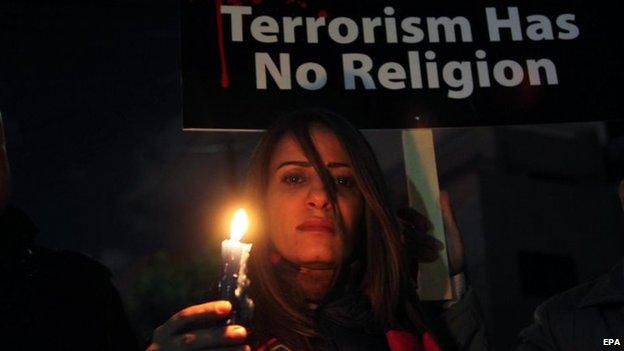 A Jordanian woman holds a candle during a gathering in front of the Egyptian embassy in Amman, Jordan, 17 February 2015
