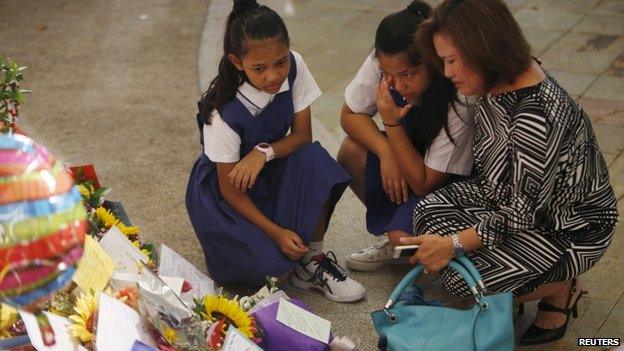 A woman and her daughters cry as they mourn the passing of former Singaporean prime minister Lee Kuan Yew, at Singapore General Hospital on 23 March 2015