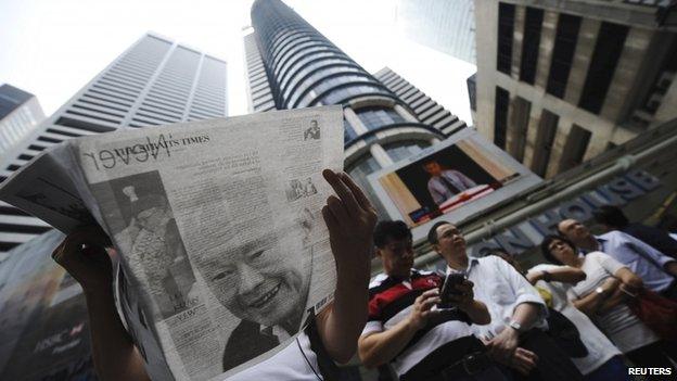 A man reads a newspaper bearing the image of Singapore's former prime minister Lee Kuan Yew, at Raffles Place in Singapore, 23 March 2015