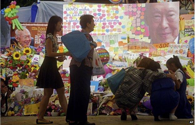 People arrive to grieve at an area set aside earlier for messages of support at a hospital where Singapore's founding prime minister Lee Yuan Yew passed away on Monday, 23 March 2015 in Singapore