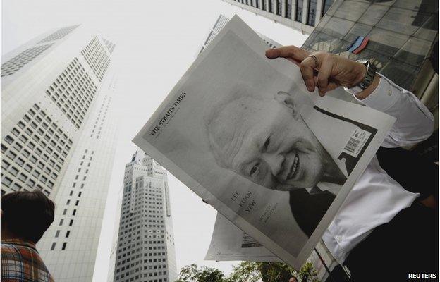 A man reads a newspaper bearing the image of Singapore's former prime minister Lee Kuan Yew, at Raffles Place in Singapore, 23 March 2015.