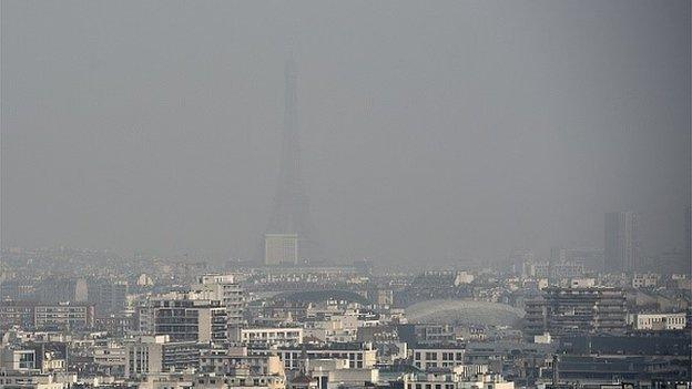 A picture taken on March 18, 2015 shows the Eiffel tower and Paris' roofs through a haze of pollution, as the city is experiencing a periodic pollution peak