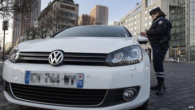 A police officer checks the documents of a driver during the enforcement of pollution control measures in Paris on March 23, 2015