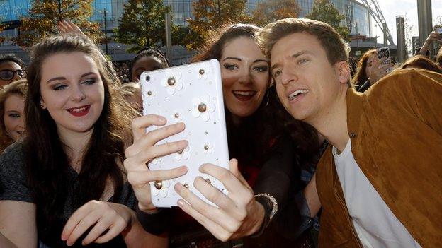 Greg James taking a selfie with fans