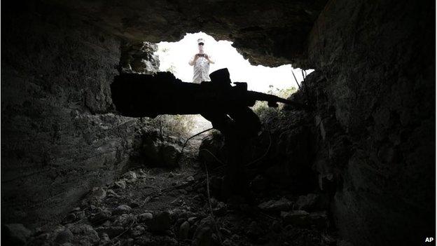 A US Marine takes a photograph of a gun emplacement at Iwo Jima (21 March 2015)