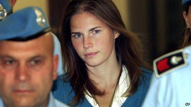 In this Sept. 26, 2008 file photo, American murder suspect Amanda Knox, centre, is escorted by Italian penitentiary police officers to Perugia's court at the end of a hearing, central Italy