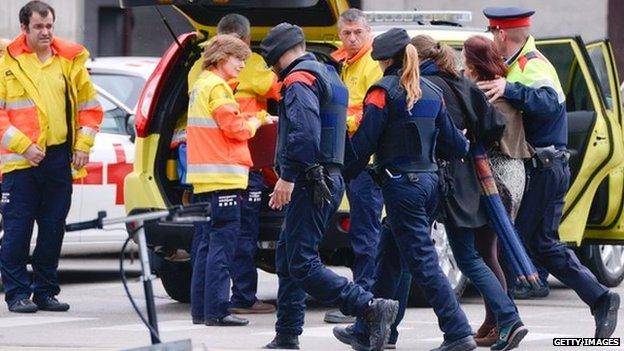 Relatives of passengers of the Germanwings plane crashed in French Alps arrive escorted by police officer at Terminal 2 of Barcelona El Prat airport on 24 March 2015