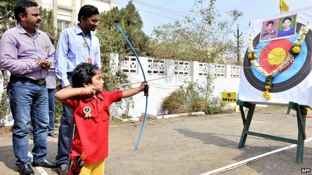 Two-year-old Indian archer Dolly Shivani Cherukuri takes aim during a world record target attempt at The Volga Archery Academy in Vijayawada some 250kms south-east of Hyderabad on March 24, 2015