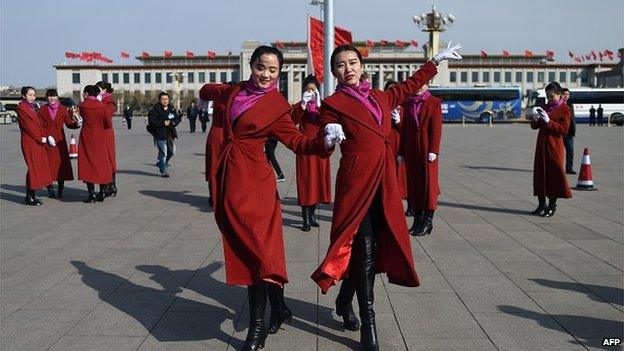 Two Chinese hostesses dance during the third session of the 12th National People's Congress outside the Great Hall of the People in Beijing on 8 March 2015