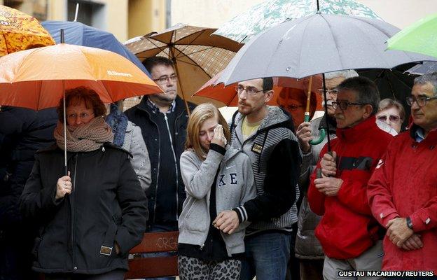 People react as they observe a minute of silence in Llinars del Valles, near Barcelona