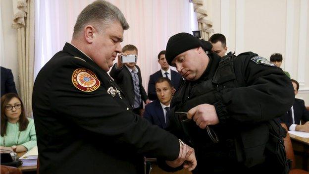 Policeman putting handcuffs on Serhiy Bochkovsky